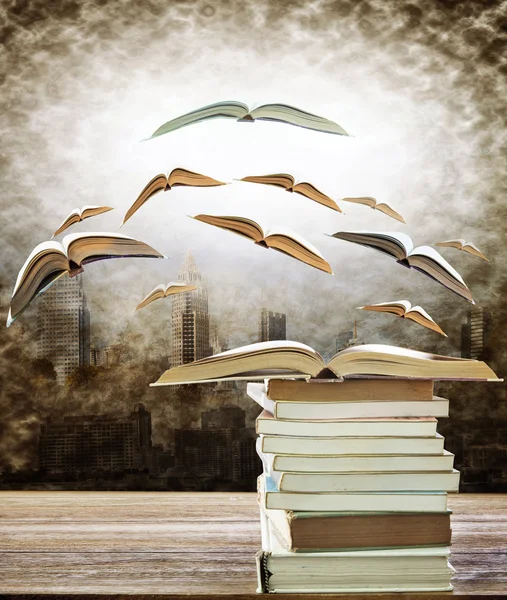 Abstract of open book on stack and flying book to the light over
