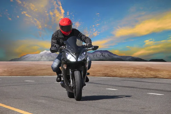 Young man riding motorcycle in asphalt road curve use for extrem