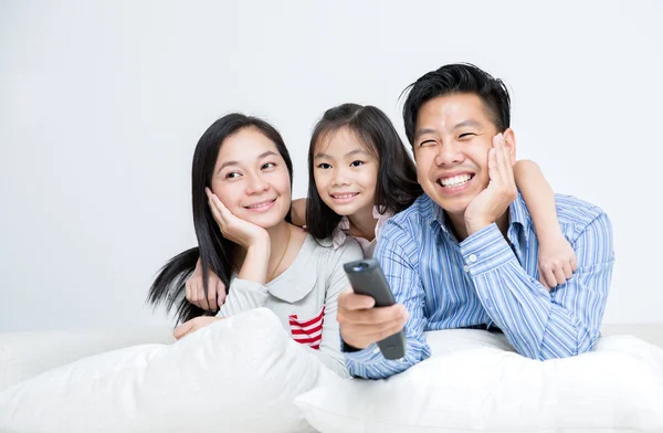 Asian Family Sitting On Sofa Watching TV