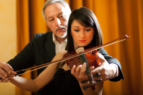 Violin teacher helping a student