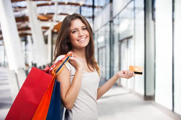 Woman holding shopping bags and a credit card
