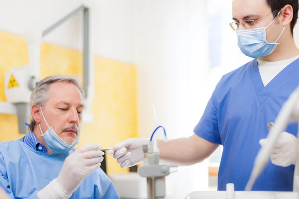 Assistant giving tools to a dentist