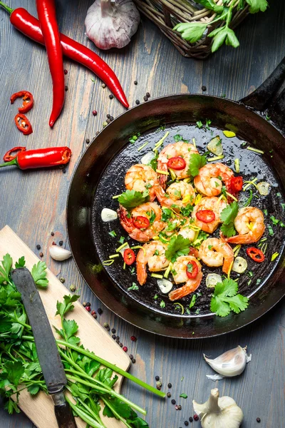 Hot shrimp fried in a pan with butter and herbs