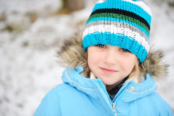 Little child girl posing outdoors in winter outfit