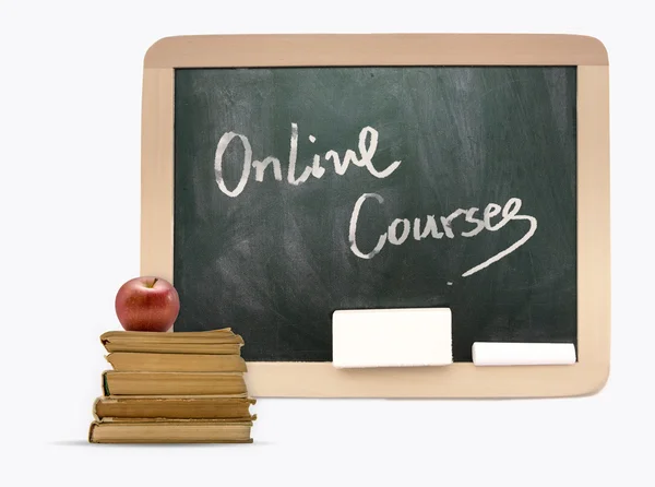 Blackboard with Online Courses written on it, books,apple