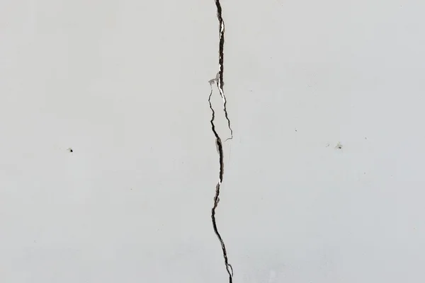 Cracks on solid white painted concrete wall