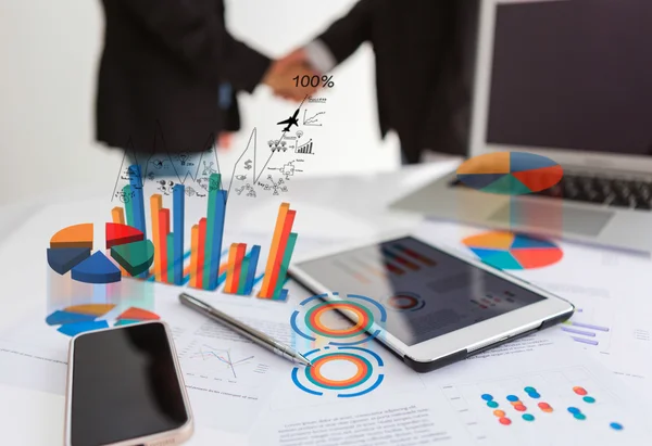 Financial charts on the table with tablet phone and pen