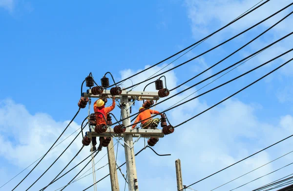 An electrical power utility worker fixes the power line