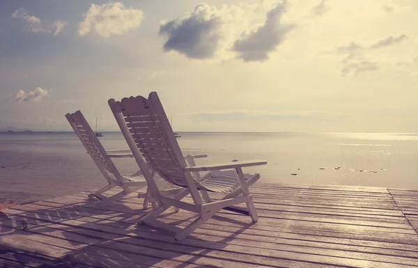 Wooden beach chair facing seascape