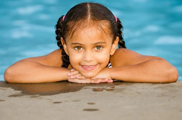 Portrait of happy pretty mixed race child by side of pool during summer