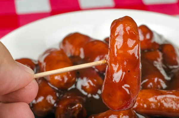 Close up of cocktail sausage with barbecue sauce