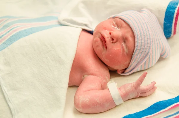 Portrait of infant with eye gel applied moments after delivery at hospital