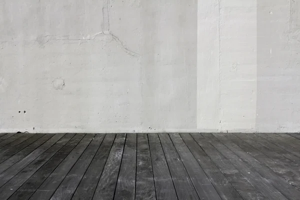 White old wall on aged wooden floor