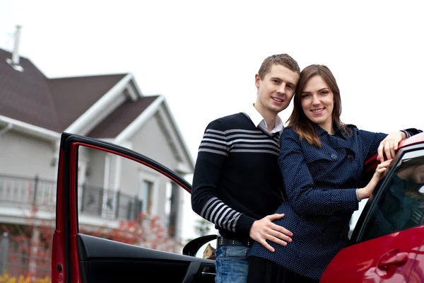 Young successful family near the car