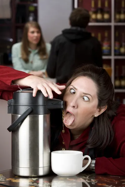 Woman drinking coffee directly from a dispenser