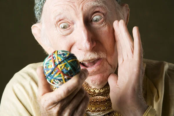 Man contemplating a rubber band ball