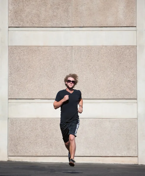 Curly haired man runs for exercise.