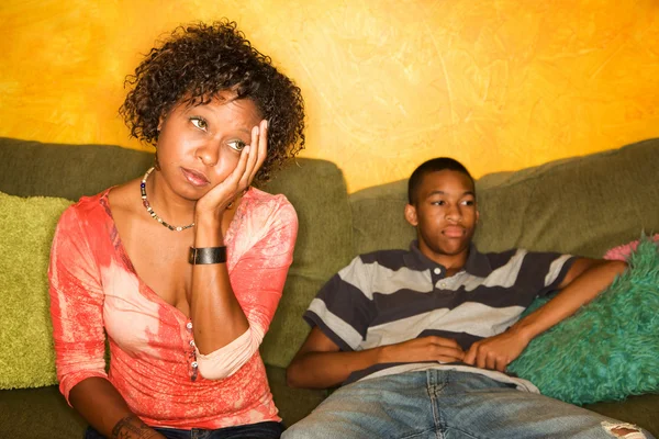 Worried African-American woman sitting with teen
