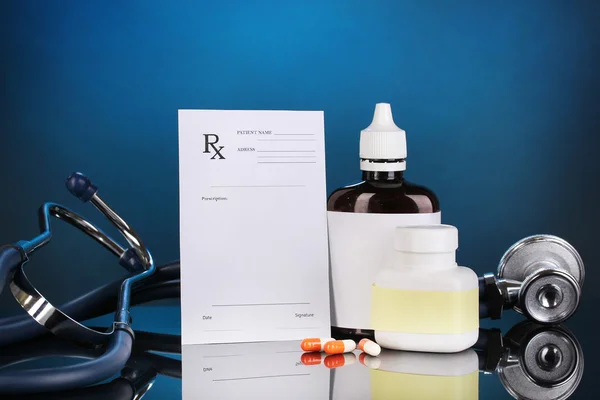 Pharmacist prescription with drops and pills isolated on blue