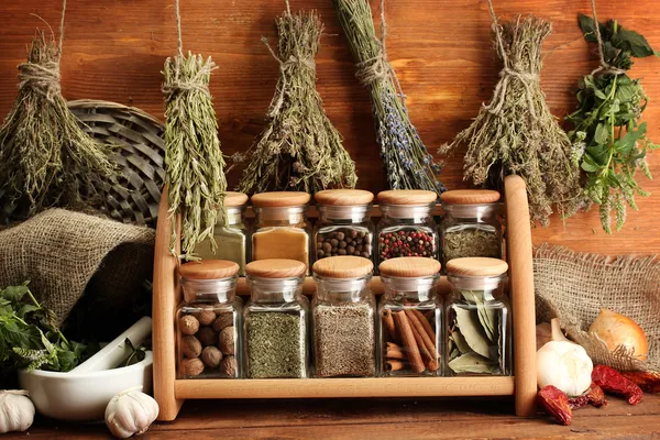 Dried herbs, spices and and pepper, on wooden background