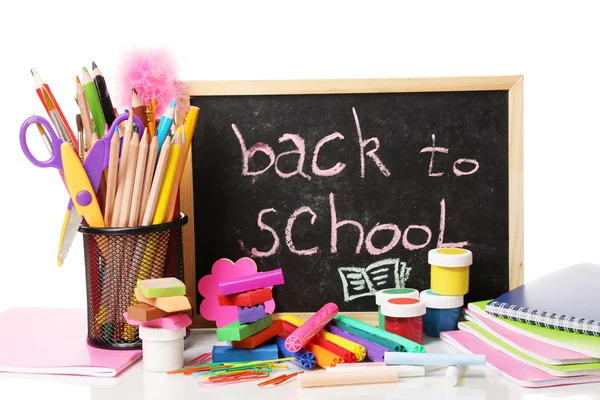 The words \'Back to School\' written in chalk on the small school desk with v