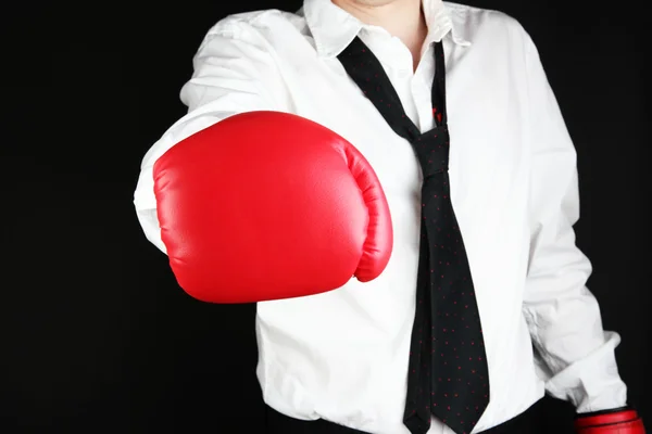 Businessman in boxing gloves isolated on black