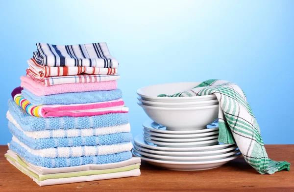 Kitchen towels with dishes on blue background close-up