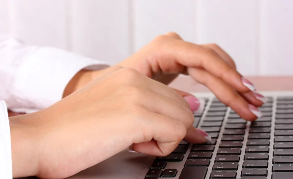 Business woman's hands typing on laptop computer, close-up
