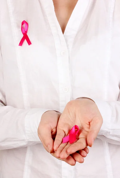 Woman with pink ribbon in hands on green background