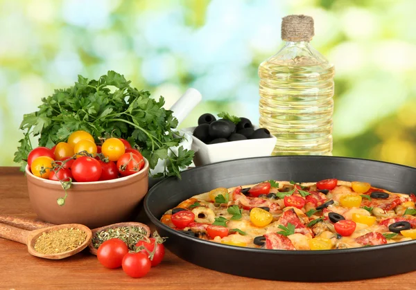 Colorful composition of delicious pizza, vegetables and spices on wooden ba