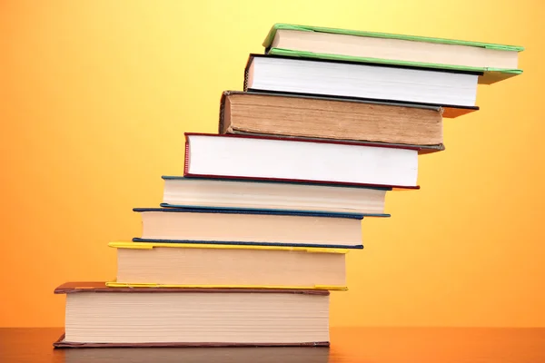 Stack of interesting books and magazines on wooden table