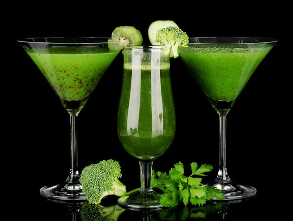 Three kinds of green juice in coctail glasses on color background
