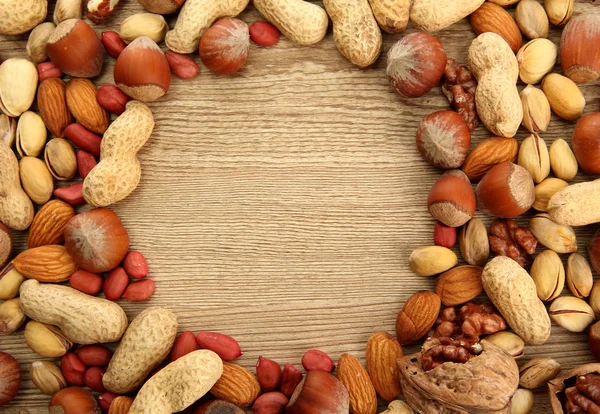 Assortment of tasty nuts on wooden background