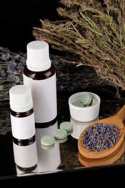 Bottles of medicines and herbs on black background. concept of homeopathy