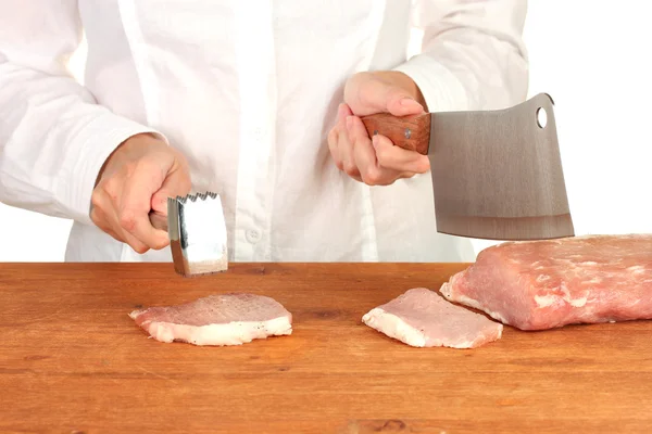 Chef cuts the meat on wooden table