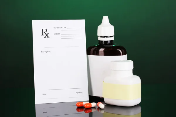 Pharmacist prescription with drops and pills isolated on green