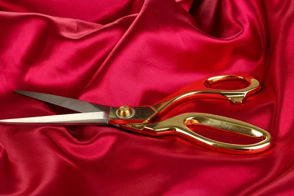 Metal scissors on red fabric