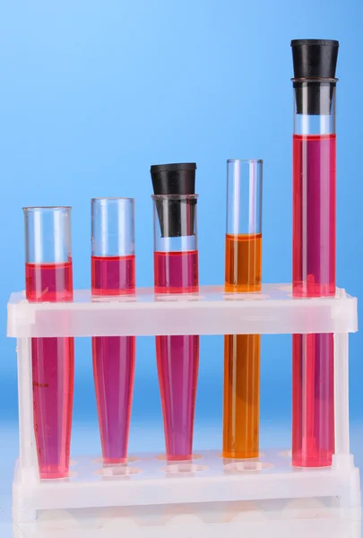 Test-tubes with a colorful solution on blue background close-up