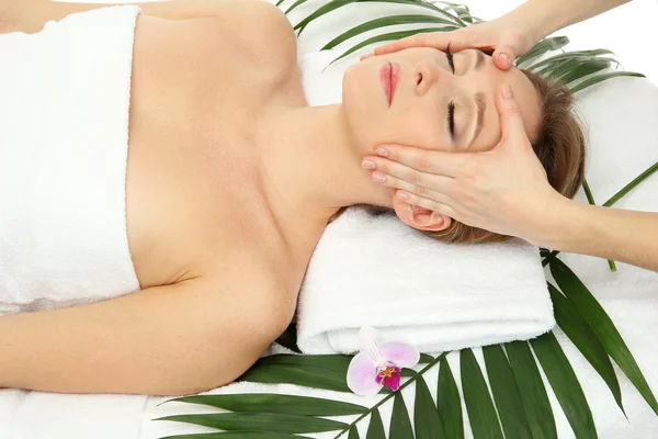 Portrait of beautiful woman in spa salon taking head massage