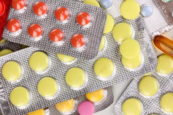 Capsules and pills packed in blisters close-up background