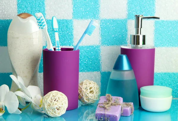 Bath accessories on shelf in bathroom on blue tile wall background