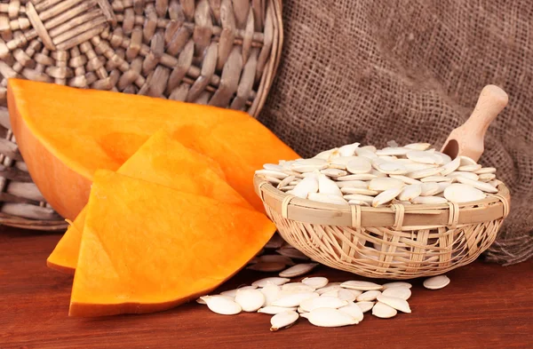 Pumpkin seeds in wicker box, on sackcloth background