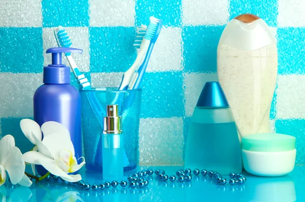 Bath accessories on shelf in bathroom on blue tile wall background