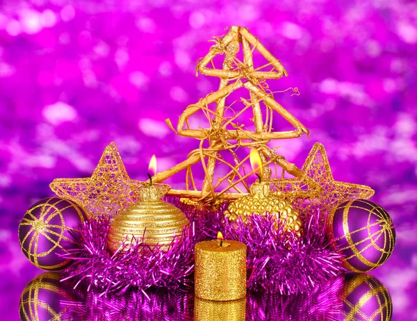 Christmas composition with candles and decorations in purple and gold colors on bright background