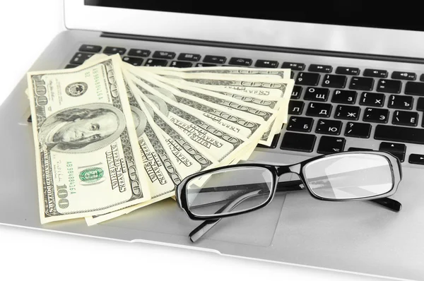 Money with glasses on laptop close-up