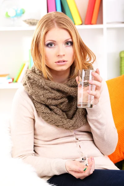 Sick woman with cold sitting on sofa