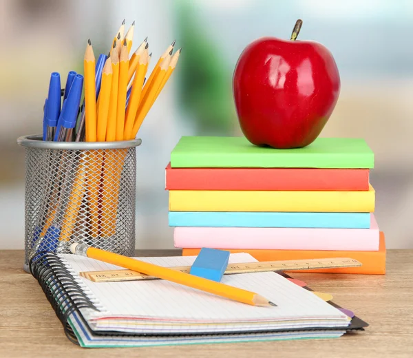 School supplies with apple on wooden table