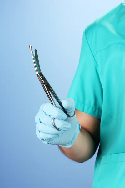 Doctor with medical instruments, on blue background