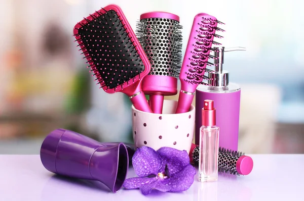 Hair brushes, hairdryer and cosmetic bottles in beauty salon