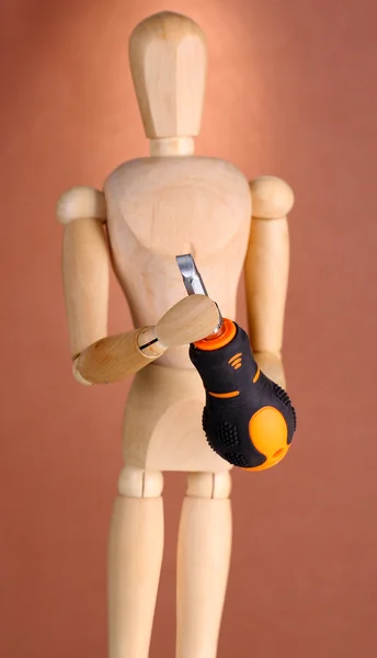 Mannequin with screwdriver, on brown background